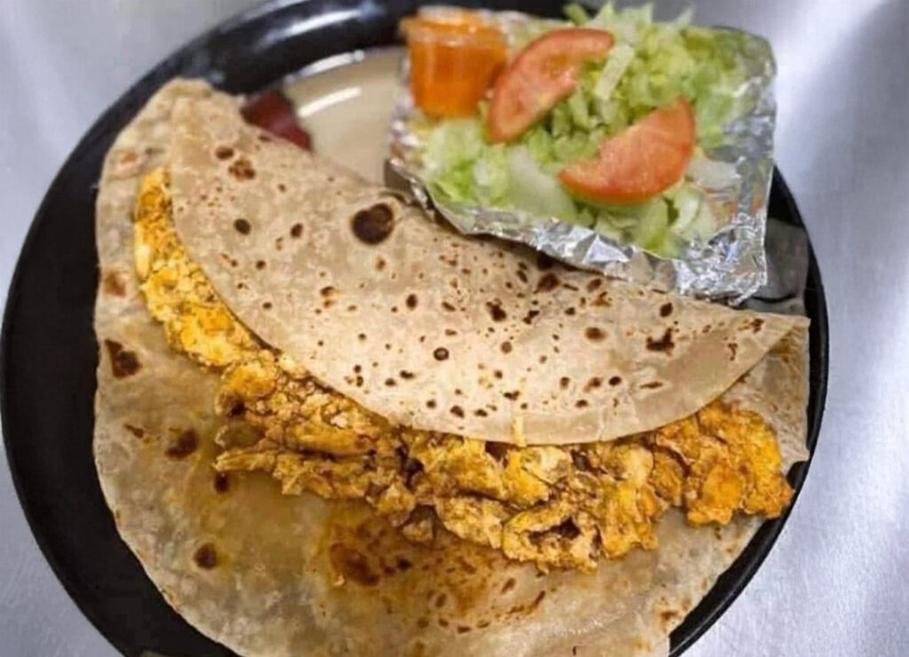 a plate with a Flour tortilla filled with scrambled egg and chorizo